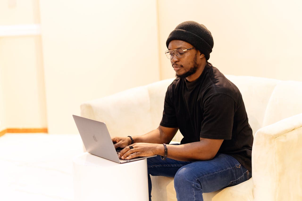 African remote worker using a laptop from a comfortable home setup
